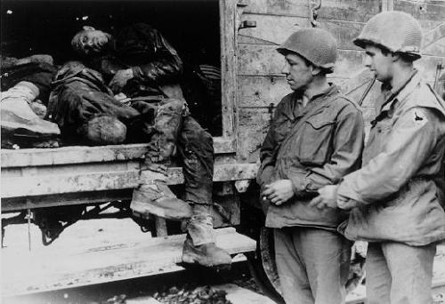 American soldiers view the bodies in one of the open railcars of the Dachau death train. USHMM